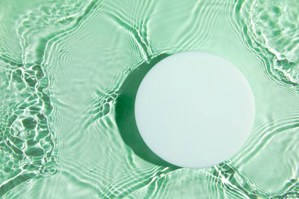 istock Empty white circle podium on transparent green clear water background 1324864211