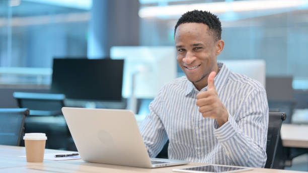 istock Thumbs Up by African Businessman with Laptop at Work 1324864978