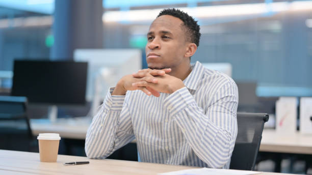 istock Young African Businessman Sitting in Office Thinking 1324865269