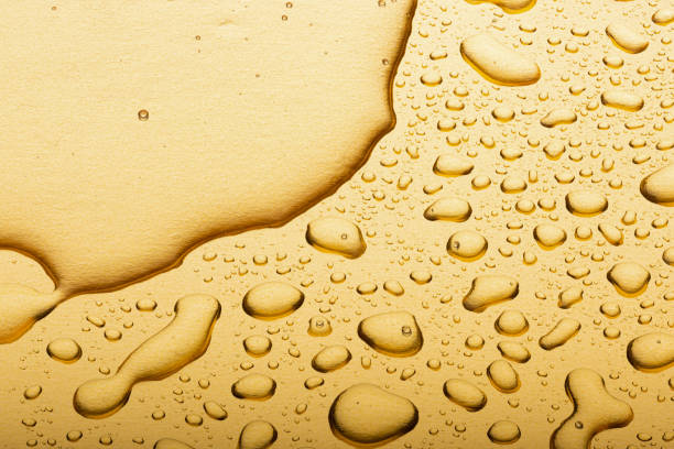 istock Drops on a gold background. A spray of moisturizing spray from above 1324865742