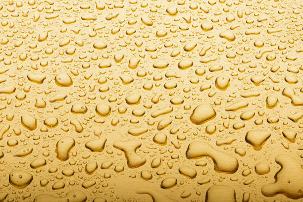 istock Drops on a gold background. A spray of moisturizing spray from above 1324865775