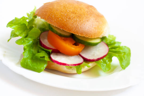 istock Vegan burger with vegetables on a white plate 1324867045