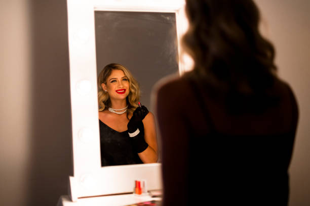 istock Glamorous woman applying lipstick reflected in vanity mirror 1324869157