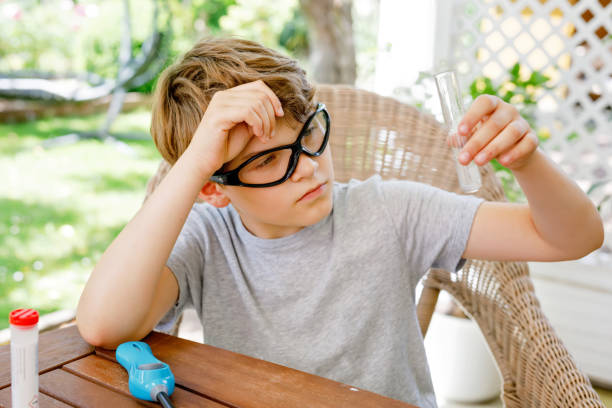istock Kid boy doing chemical experiment in laboratory at school. Child with protective glasses study using pipette dropping liquid to test tube , caucasian , biochemistry . chemistry class. Summer school. 1324869411