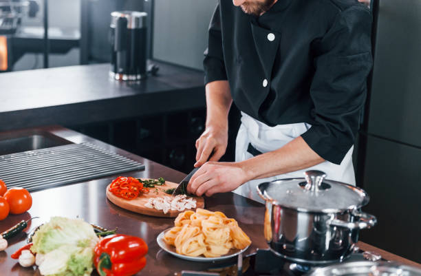 istock Close up view of professional young chef cook in uniform that working on the kitchen 1324870407