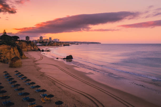 восход солнца на пляже рассвета - алгарве стоковые фото и изображения