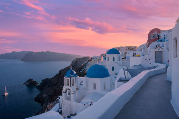 Sunset behind the blue domes of Oia village, Santorini, Greece Classical sunset view of the picturesque old town of Oia village on Santorini island, Greece. Included in the picture are the famous blue domes of the Greek Orthodox chapels and small churches. santorin stock pictures, royalty-free photos & images