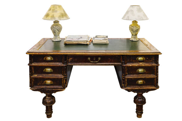 Antique writing desk, with table lamps, magazines and brochures. Isolated on white background