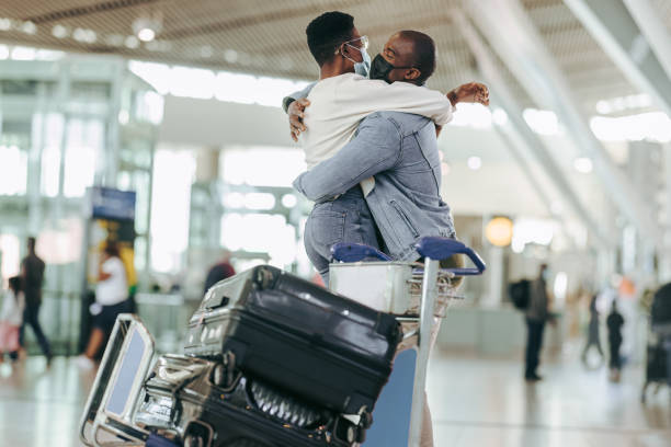 istock Man hugging woman at airport terminal 1324872443