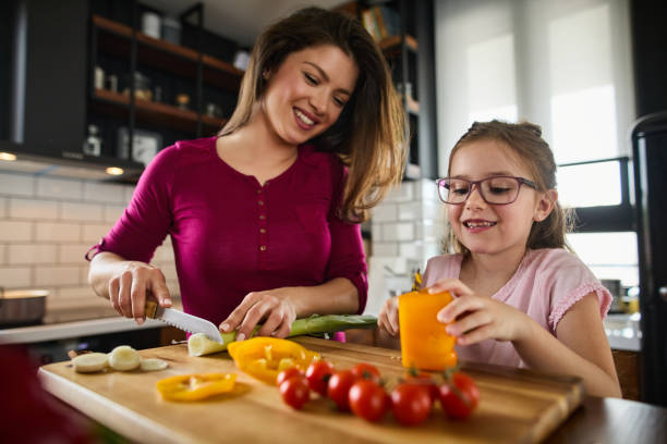 istock Mother and daughter cutting vegetable in the kitchen 1324872453