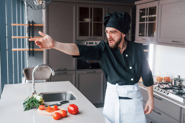 istock Professional young chef cook in uniform making salad on the kitchen 1324872484