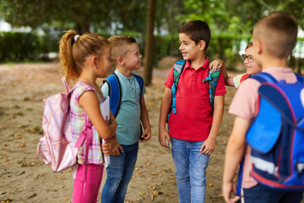 istock Group of school children talking together in schoolyard 1324873621