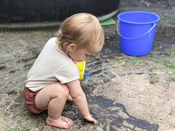 istock Baby girl playing with water 1324873693