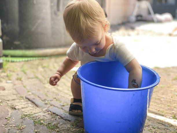istock Baby girl playing with water 1324873701