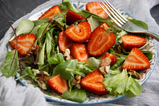 istock salad with strawberries, nuts on a concrete background 1324873960