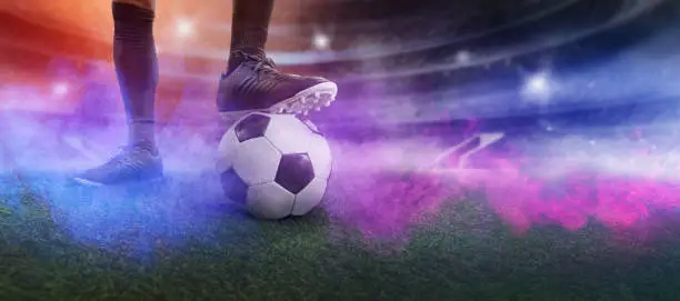 Photo of Feet of soccer player step on soccer ball for kick off in stadium