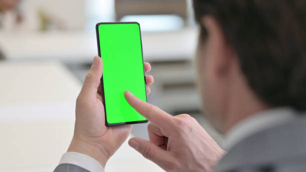 istock Businessman Holding Smartphone with Green Screen at Work 1324875975