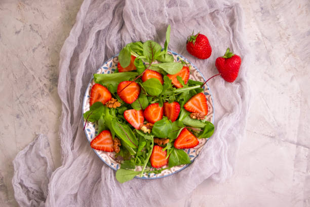 istock salad with strawberries, nuts on a concrete background 1324876012