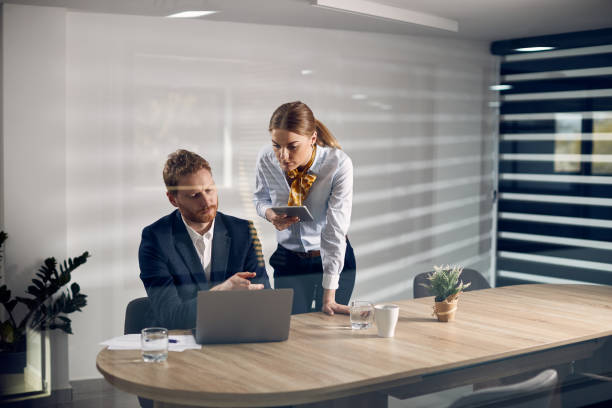 istock Two business coworkers cooperating while working on laptop in the office. 1324876995