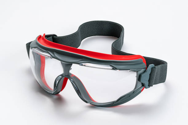 istock Closeup view of gray and red frame with clear polycarbonate lens goggles on white background. 1324877184