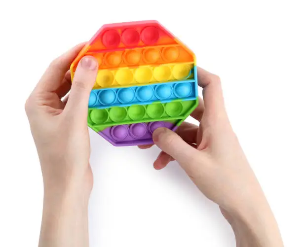 Photo of Woman using pop it fidget toy on white background, closeup