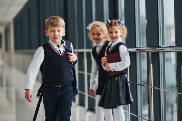 istock School kids in uniform together in corridor. Conception of education 1324881497