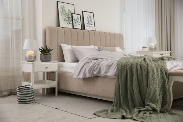 istock Bed with stylish grey linens near white wall in room 1324882910