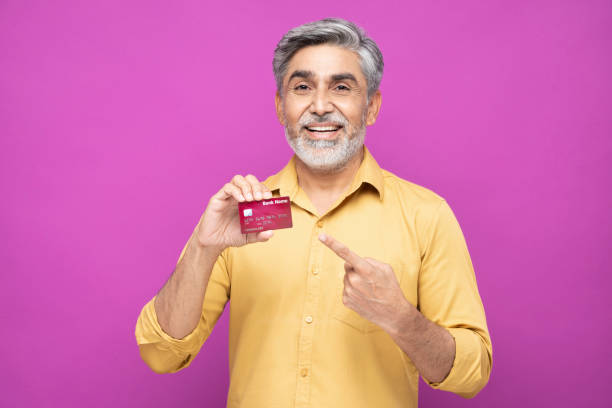 Portrait of handsome mature man standing isolated over pink background:- stock photo Adult, mature men, India, Indian ethnicity, 40-49 years, rolled up sleeves stock pictures, royalty-free photos & images