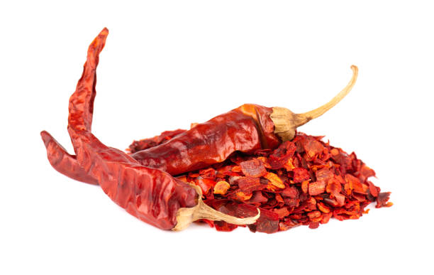 Dried red chili flakes with seeds, isolated on white background. Chopped chilli cayenne pepper. Spices and herbs.