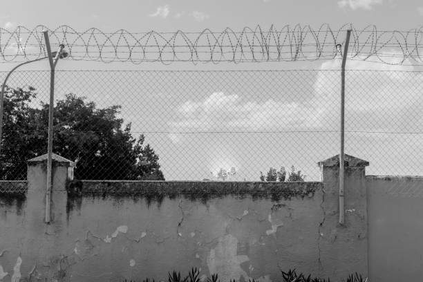 istock wall and barbed wire in the foreground 1324884460