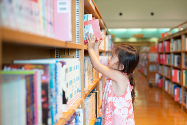 istock Little girl choosing a book 1324885243