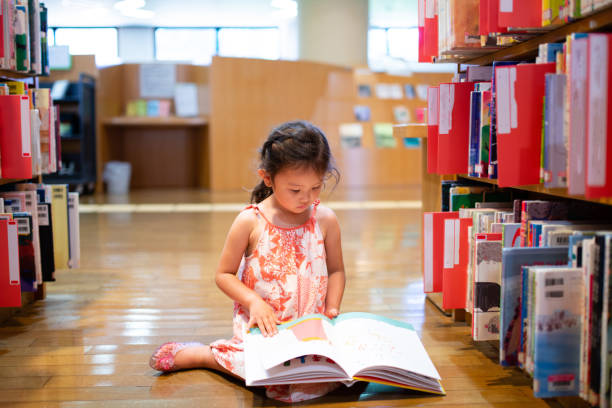 istock Little girl choosing a book 1324885255