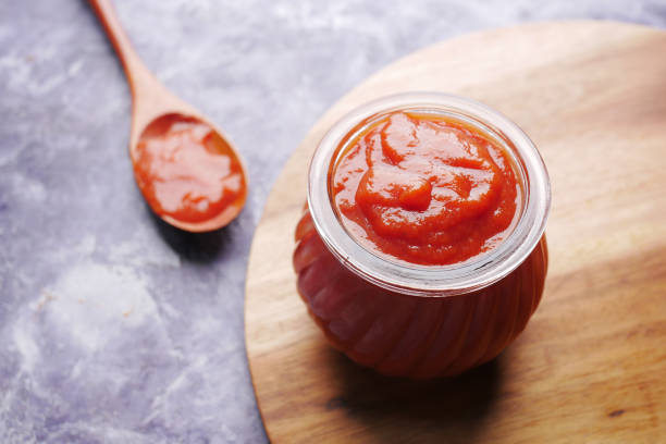 istock tomato sauce in a small jar with fresh tomato on table 1324886768