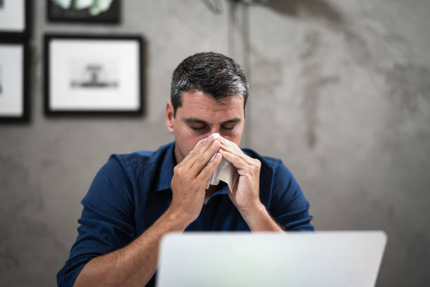 istock Businessman blowing nose while working in the office 1324888446