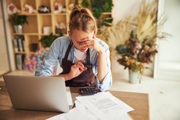 istock Serious young florist focused on her calculations 1324889449