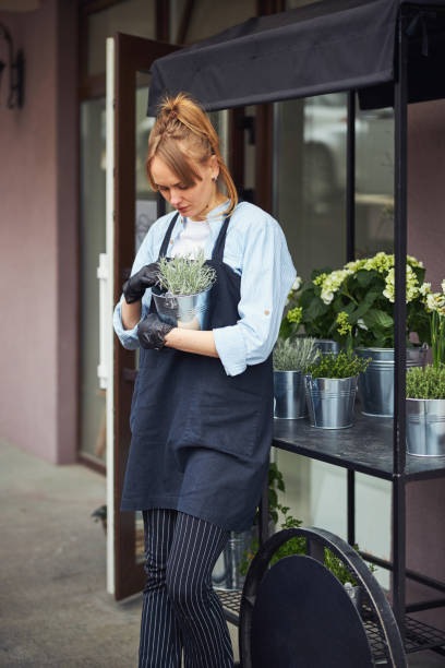 istock Experienced floriculturist staring at potted plants in her hands 1324889531