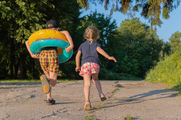 istock Back view of two kids run to swim. 1324890584