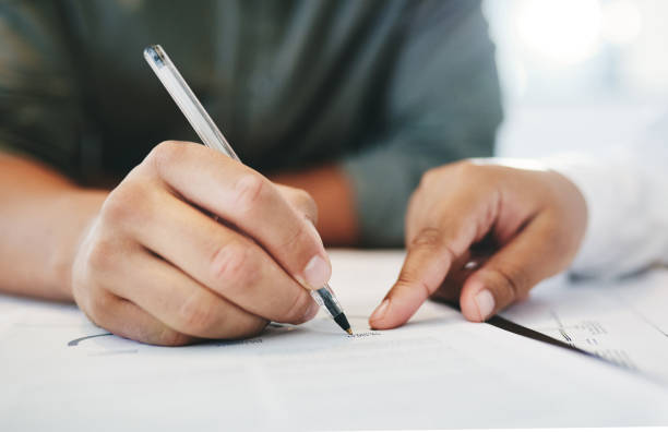 istock Shot of two unrecognizable businesspeople taking notes in an office 1324891122
