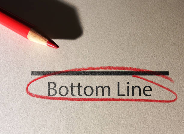 Bottom Line text circled in red pencil on textured paper Bottom Line text circled in red pencil on textured paper surface at the bottom of photos stock pictures, royalty-free photos & images