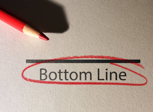 Bottom Line text circled in red pencil on textured paper Bottom Line text circled in red pencil on textured paper surface at the bottom of stock pictures, royalty-free photos & images