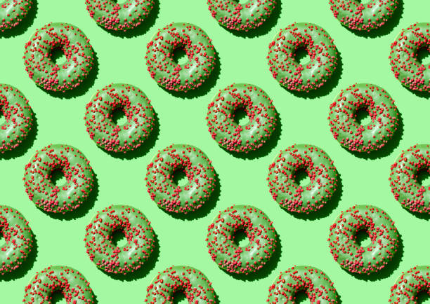 istock Green donut is a seamless pattern on a green background. Close up 1324893490