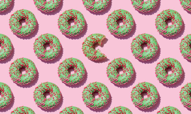 istock Green donut seamless pattern on pink background.Close up. 1324893496