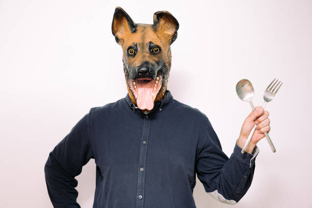 istock person with a dog mask showing eating utensils 1324893536