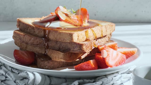 French toast with strawberries, cream and maple syrup.