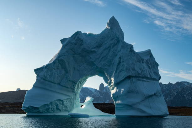 istock A towering, arched iceberg stands or floats in a protected bay on a sunny, partly cloudy day 1324894821