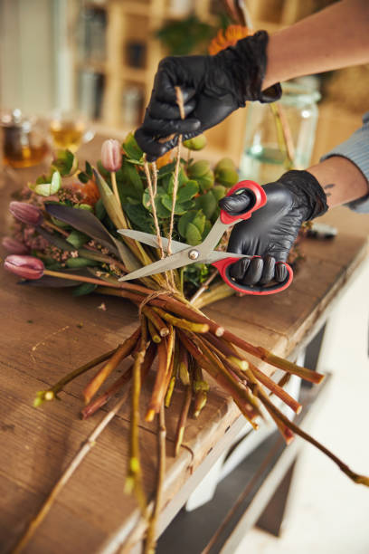 istock Female hands cutting a string wrapped around a flower bunch 1324895871