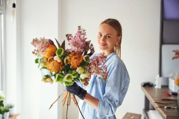 istock Joyous floral designer holding a bouquet in her gloved hand 1324895949