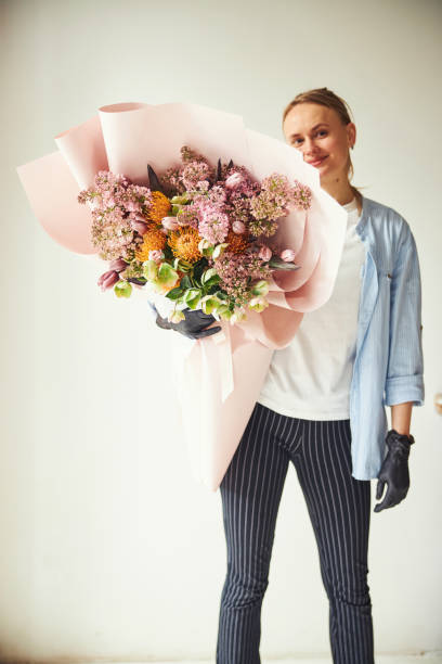 istock Pleased florist with a completed flower arrangement posing for the camera 1324895967