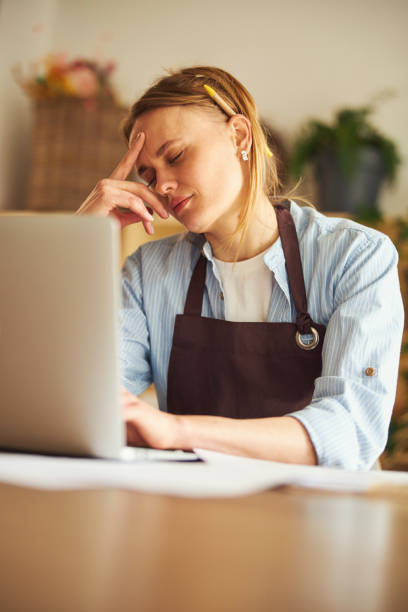 istock Tired professional floral arranger dozing before her laptop 1324895973