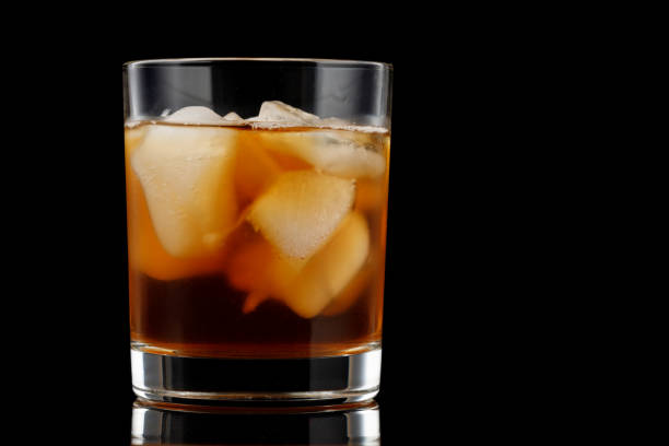 istock Tea with ice in a glass on a black background. 1324898230